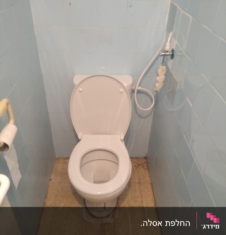 אסלה עם מושב פתוח וצינור מים ליד